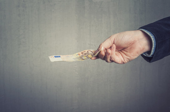 Businessman`s hand holding a 5o euro banknote. Paying concept.