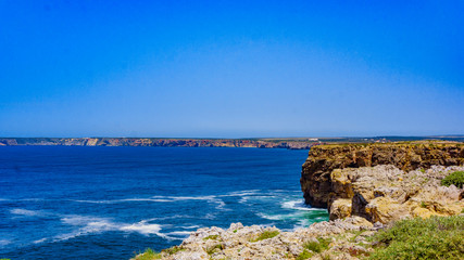 Fototapeta na wymiar Ocean wave background. Cliff coastline in Sagres, Algarve, Portugal