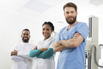 Smiling Radiologists Standing Arms Crossed In Examination Room