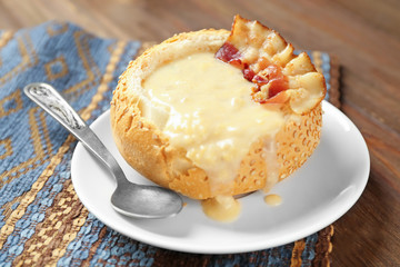 Delicious cream soup in bread on table