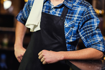 Barman at work in pub,Portrait of cheerful barman worker standing,Waiter giving menus,A pub.Bar.Restaurant.Classic.Evening.European restaurant.European bar.American restaurant.American bar.