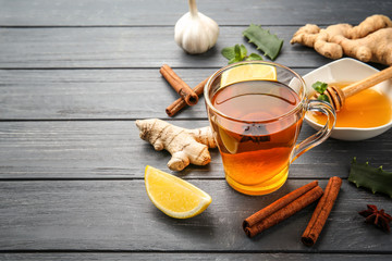 Hot drink with honey, lemon and ginger for cough remedy on wooden table