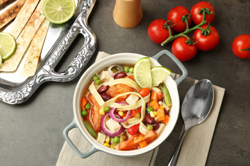 Chicken tortilla soup with vegetables on kitchen table