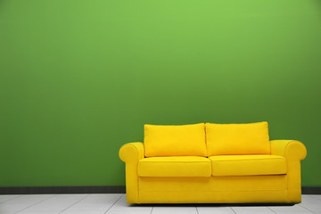 Room interior with sofa on color wall background