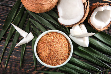 Fototapeta na wymiar Bowl of brown sugar and coconut on wooden background
