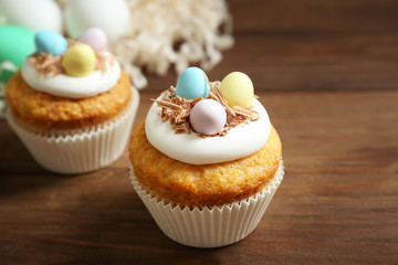 Tasty Easter cupcakes on wooden table