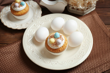 White plates with delicious Easter cupcake on table