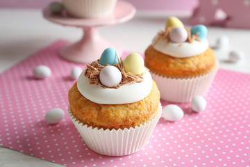 Delicious Easter cupcakes on white table