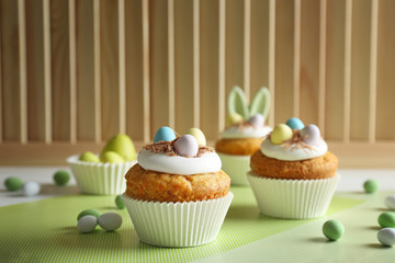 Decorated Easter cupcakes on white table with green table-napkin