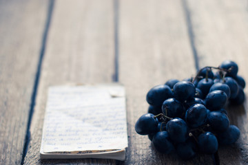Grapes on a wooden background with paper