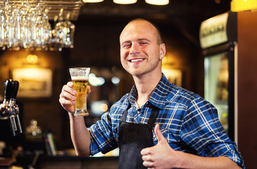 Bartender pouring the fresh beer in pub,barman hand at beer tap pouring a draught lager beer,beer from the tap,Filling glass with beer,fresh beer,pub.Bar.Restaurant.European bar.American bar.