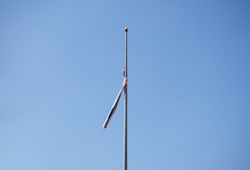Obraz premium Old lacking spin Thai flag on blue sky.