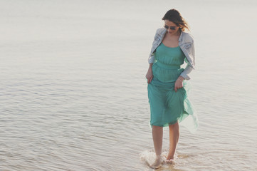 Amazing young woman in green dress near the sea