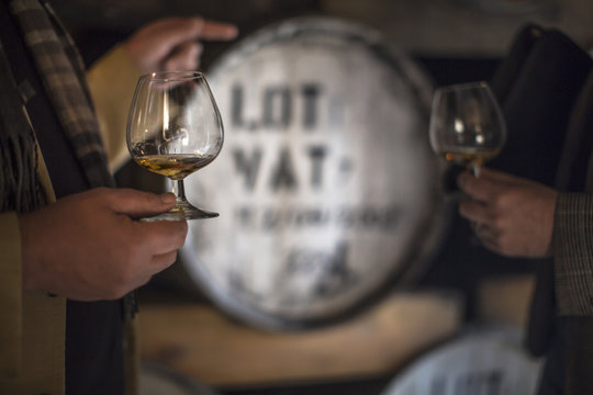 People in distillery tasting whiskey