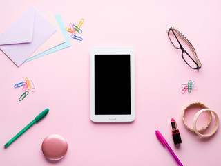Pink pastel flat lay with gadget tablet smartphone stationery glasses woman lipstick, bracelets