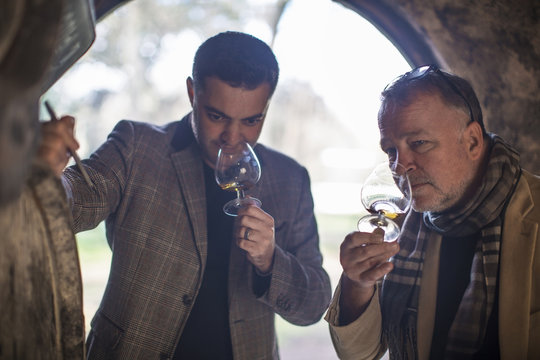 People in distillery tasting whiskey