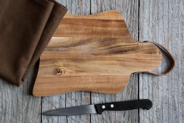 wooden cutting board with a knife and a napkin