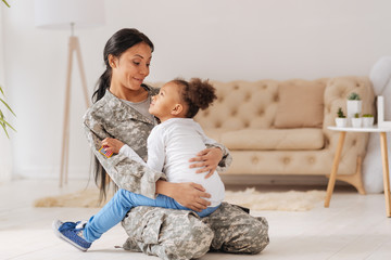 Confident caring mom holding her little girl in her arms