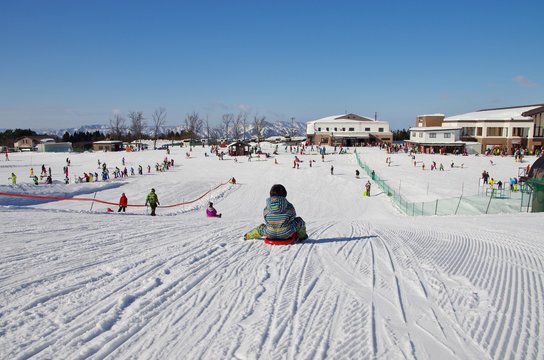 スキー場でそり遊びをする子供