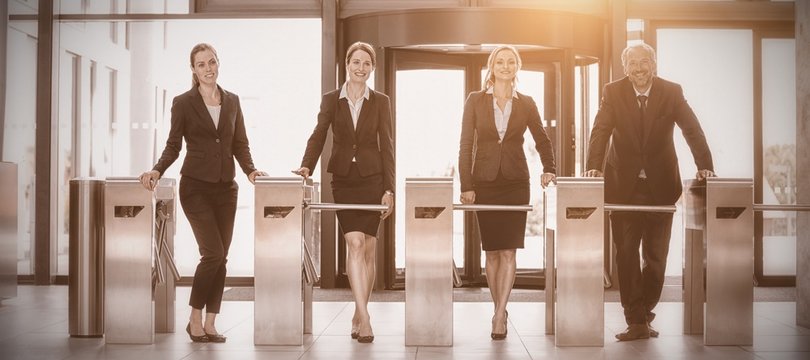 Businesspeople Standing At Turnstile Gate