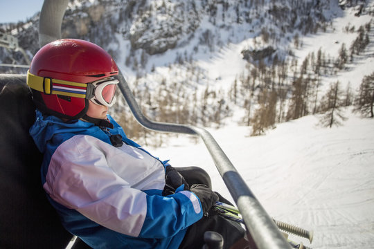 Side view of boy traveling in ski lift