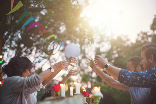 Group of friends making a toast and enjoying a garden party