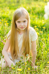 A beautiful little girl runs through a flowering garden in the spring