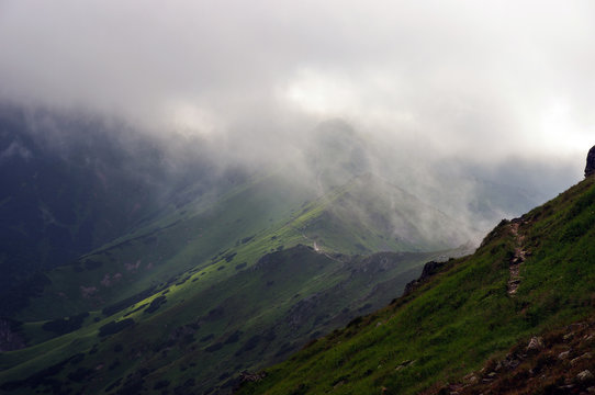 Fototapeta Mountain trail on the ridge among the mists. Tatry.