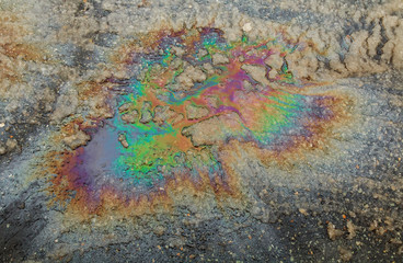 Puddled water polluted with fuel spill.