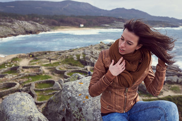 mujer joven al viento sobre el Castro de Baroña