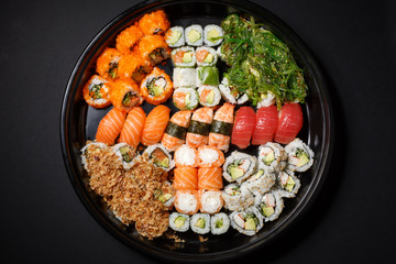 A large set of sushi and rolls view from above. A lot of food in one plate. Dishes from raw fish Japanese food
