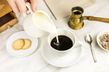 Milk poured into cup of coffee