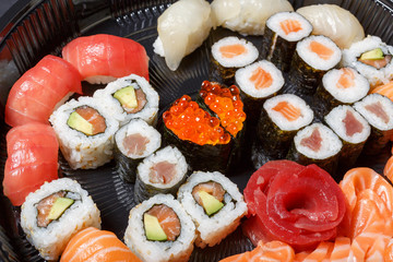 A large set of sushi and rolls view from above. A lot of food in one plate. Dishes from raw fish Japanese food.A dish in a romantic style. I love you. Heart with red fish caviar