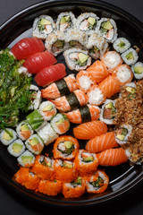 A large set of sushi and rolls view from above. A lot of food in one plate. Dishes from raw fish Japanese food