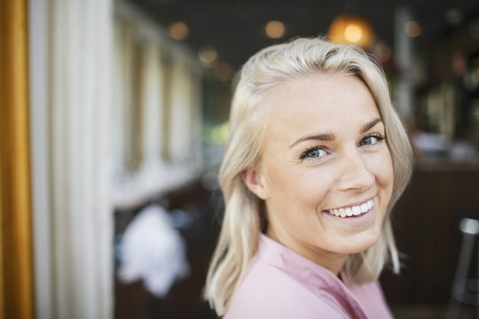 Portrait Of Happy Blond Businesswoman At Restaurant