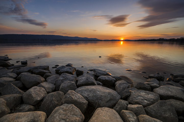 Sonnenuntergang am Bodensee mit Steinen am Seeufer 