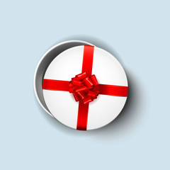 Open white round gift box with shiny red beautiful curly bow and ribbon. Top view, close up. Isolated on blue Background
