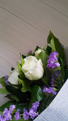White rose bouquet lay on white wooden board