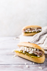 Traditional dutch snack, seafood sandwich with herring, onions and pickled cucumber. Broodje haring. Copy space.