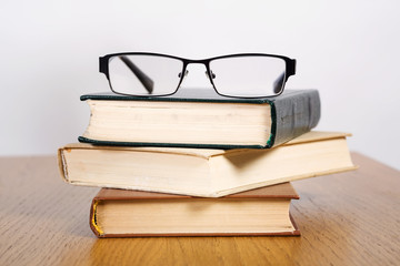 Pile of open books and glasses