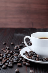 Coffee cup and coffee beans on wooden background