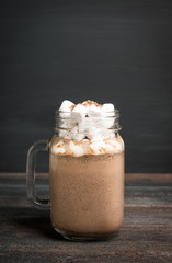 Hot chocolate with marshmallow on the wooden background. Shallow depth of field.