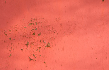 Old red paint on a metal wall. Texture of iron with cracks and rust. Horizontal background.