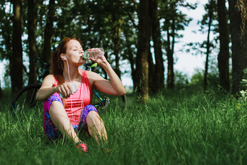 Fototapeta premium Attractive woman drinks water from a bottle