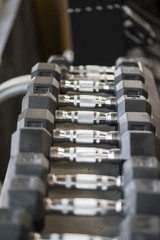 Naklejka premium Closeup of weightlifting dumbbells on a rack in a gym 