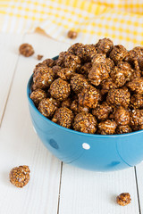 Chocolate caramel popcorn in cup on white wooden table