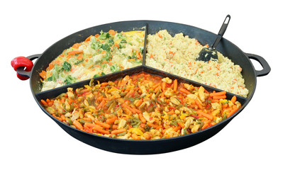 Fast street food - rice, boiled on couple, and other stewed vegetables on big iron frying pan.