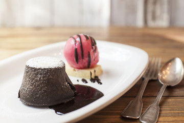 Chocolate Volcano Lava cake,  with brown sauce, and straberry ice cream ball