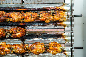 roasting chickens on a rotisserie at a market