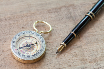Fototapeta na wymiar vintage compass and pen on wood floor